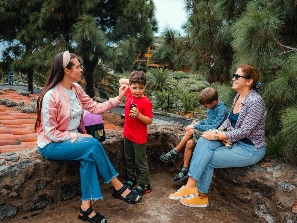 Two parents and their children sitting together in a park